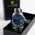 Rolex watch with blue face and silver bracelet in a black box